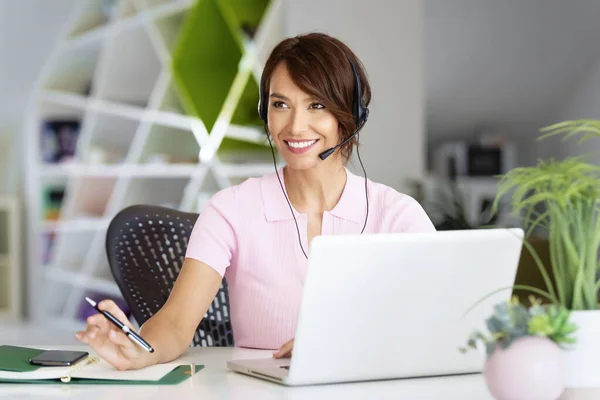 Kundendienstassistentin Mit Headset Während Sie Hinter Ihrem Computer Sitzt Und — Stockfoto