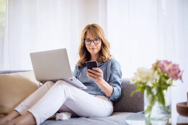 Mulher Negócios Sorrindo Mensagens Texto Usando Seu Laptop Enquanto Senta — Fotografia de Stock