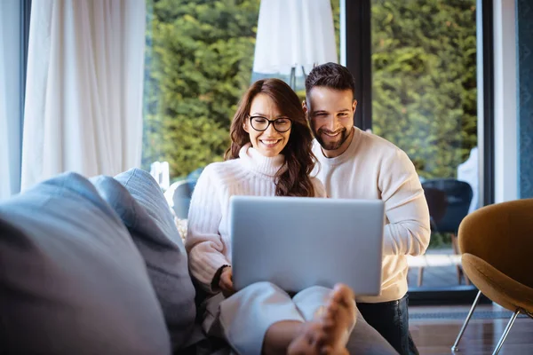哈普夫妇一起在沙发上放松 在网上浏览的时候 快乐的女人和英俊的男人在用笔记本电脑 — 图库照片