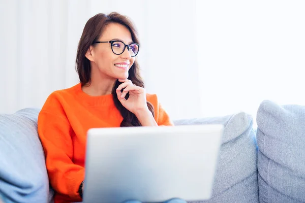 Tiro Mulher Feliz Usando Seu Laptop Enquanto Sentada Sofá Casa — Fotografia de Stock