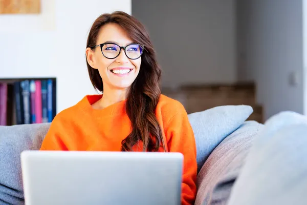 Evdeki Kanepede Oturup Internette Gezinirken Mutlu Bir Kadının Dizüstü Bilgisayarını — Stok fotoğraf