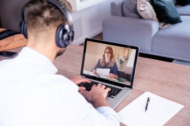 İş adamının dizüstü bilgisayarının arkasında oturup tartışırken ve internet üzerinden iş görüşmeleri yaparken görüntüsü. Merkez Ofis. 