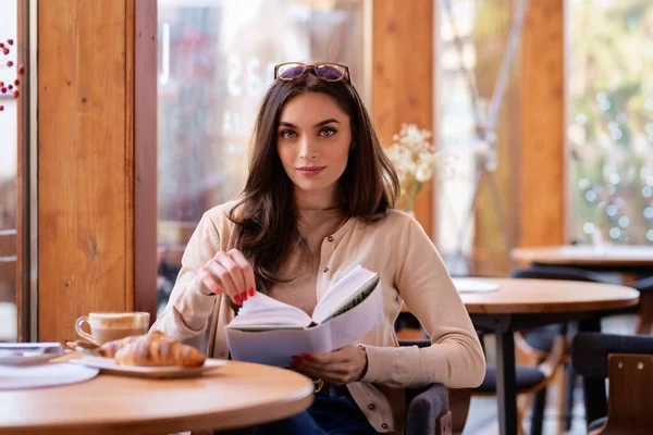 Retrato Una Mujer Sonriente Leyendo Libro Mientras Está Sentada Mesa — Foto de Stock