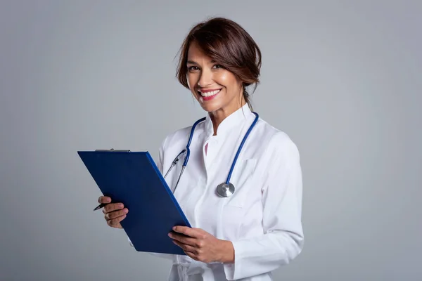 Una Doctora Sonriente Sosteniendo Portapapeles Mano Mientras Mira Cámara Sonríe — Foto de Stock