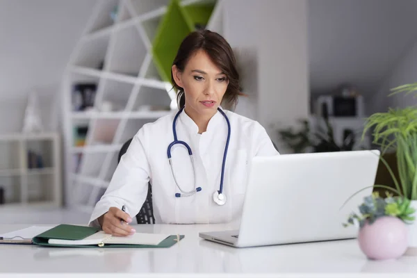 Sonriente Trabajadora Salud Haciendo Algunos Trámites Usando Portátil Mientras Trabaja —  Fotos de Stock