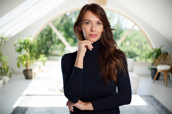 Attractive Woman Wearing Turtleneck Sweater Looking Camera While Standing Indoor — Stockfoto