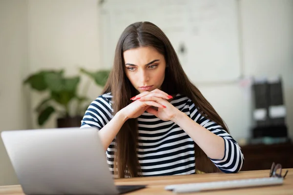 Thinking Young Woman Using Her Laptop While Sitting Desk Home — Φωτογραφία Αρχείου