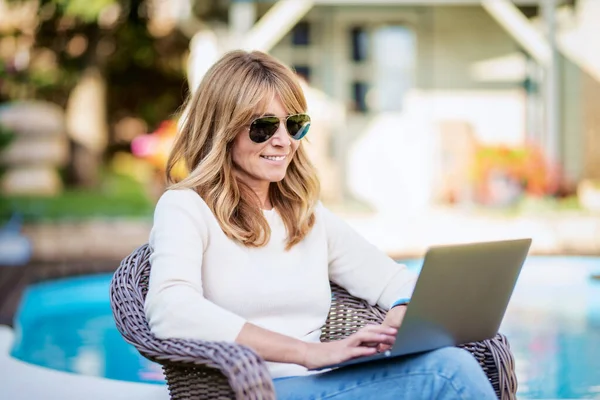 Attractive Middle Aged Woman Using Laptop While Sitting Backyard Home — Stockfoto