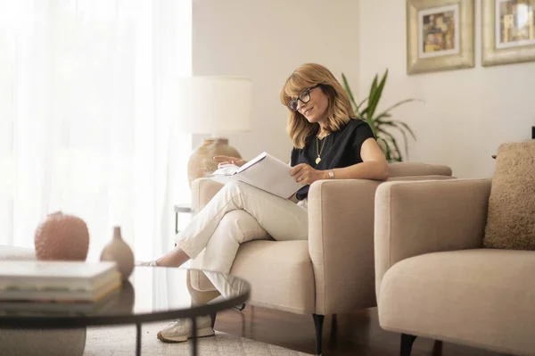 Full Length Smiling Woman Reading Book While Relaxing Armchair Home — Photo