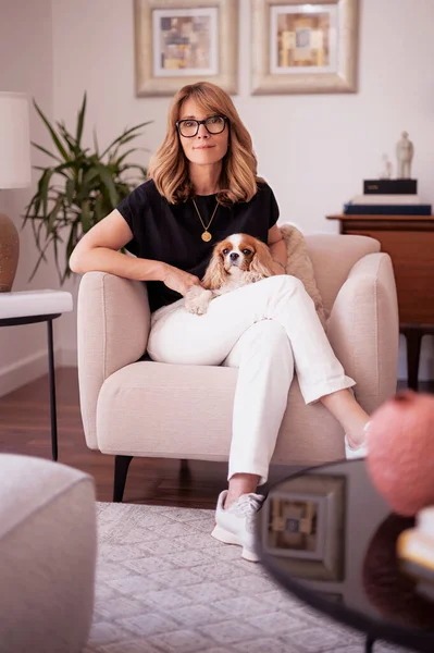 Happy Middle Aged Woman Relaxing Home Armchair Her Cute Puppy —  Fotos de Stock