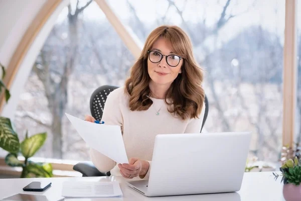 Shot Middle Aged Businesswoman Holding Document Her Hand Using Laptop — Stockfoto