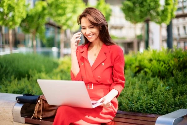 Attractive Businesswoman Using Her Laptop Mobile Phone While Sitting Bench — Foto Stock
