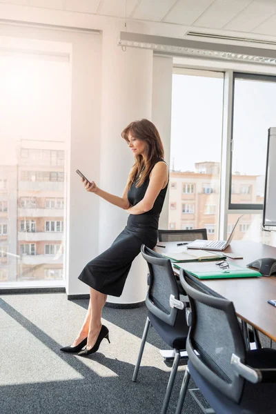 Attractive Businesswoman Using Mobile Phone Text Messaging While Standing Modern — Stok fotoğraf