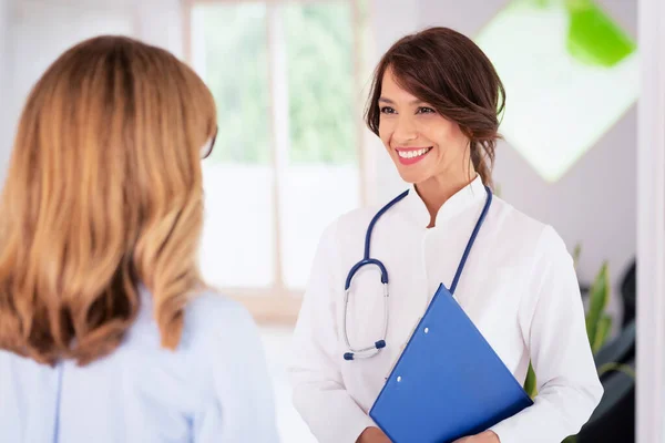 Female doctor working in the office and listening to the patient while she is explaining her symptoms and consulting.