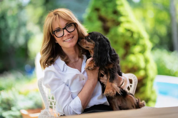 Portrait Happy Middle Aged Woman Holding Her Cute Puppy Sitting — Stockfoto