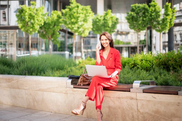 Empresária Atraente Usando Seu Laptop Celular Enquanto Senta Banco Parque — Fotografia de Stock