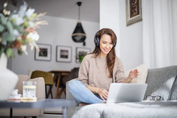 Hermosa Mujer Mediana Edad Con Auriculares Usando Ordenador Portátil Mientras Imagen de archivo