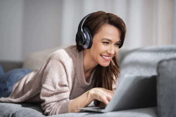 Piękna Kobieta Średnim Wieku Słuchawką Przy Użyciu Laptopa Podczas Przeglądania Obraz Stockowy