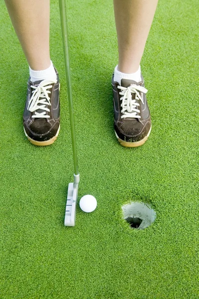 Vrouw zetten golfbal — Stockfoto