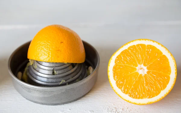 Соковыжималка и апельсин — стоковое фото