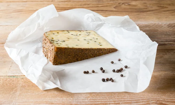 Queso de pimienta sobre mesa de madera — Foto de Stock