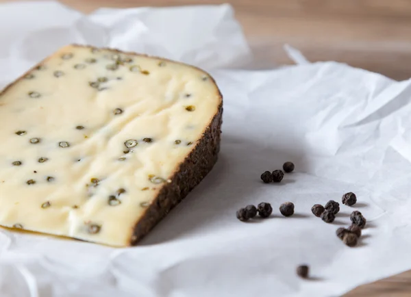 Queso de pimienta sobre mesa de madera — Foto de Stock