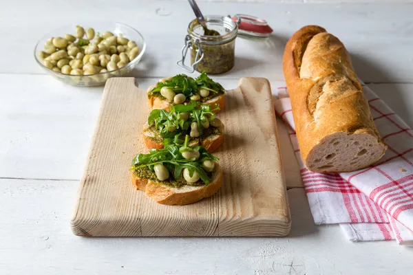 Bruschetta with beans and rocket — Stock Photo, Image