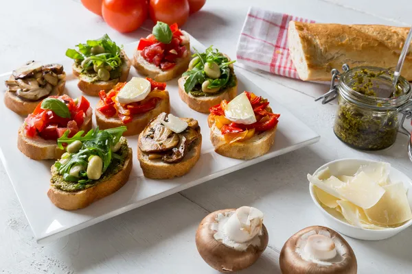 Bruschetta with beans and arugula, mushrooms, goat cheese — Stock Photo, Image