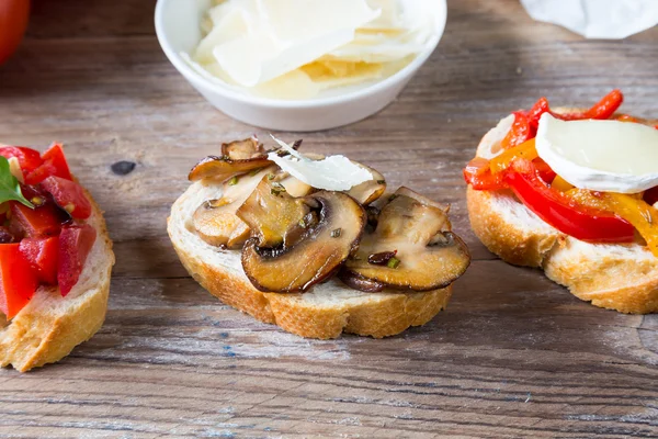 Bruschetta with beans and arugula, mushrooms, goat cheese — Stock Photo, Image