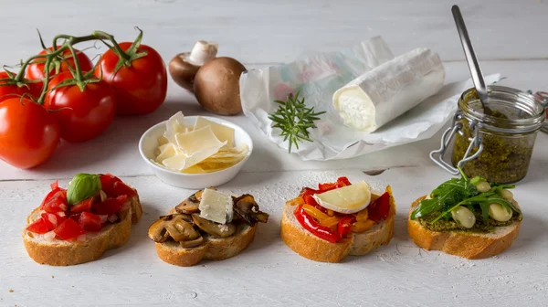 Bruschetta with beans and arugula, mushrooms, goat cheese — Stock Photo, Image