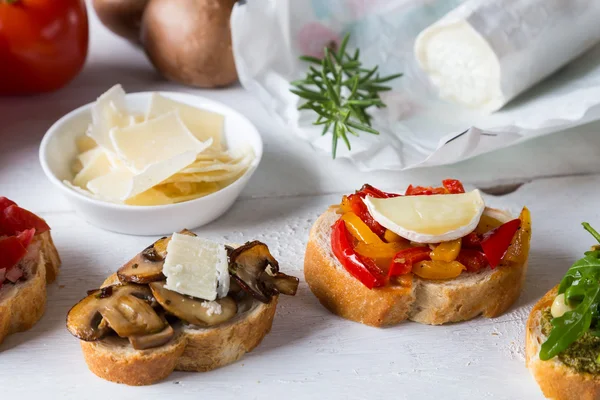 Bruschetta with beans and arugula, mushrooms, goat cheese — Stock Photo, Image