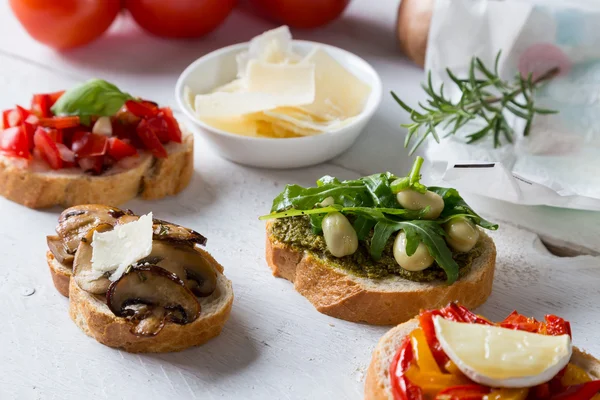 Bruschetta with beans and arugula, mushrooms, goat cheese — Stock Photo, Image