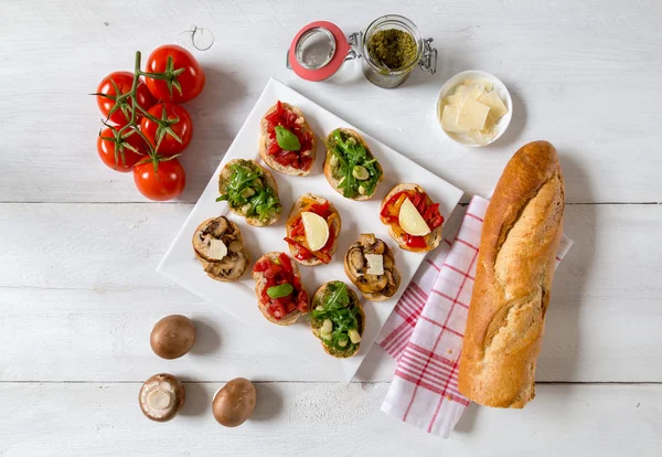 Bruschetta with beans and arugula, mushrooms, goat cheese — Stock Photo, Image