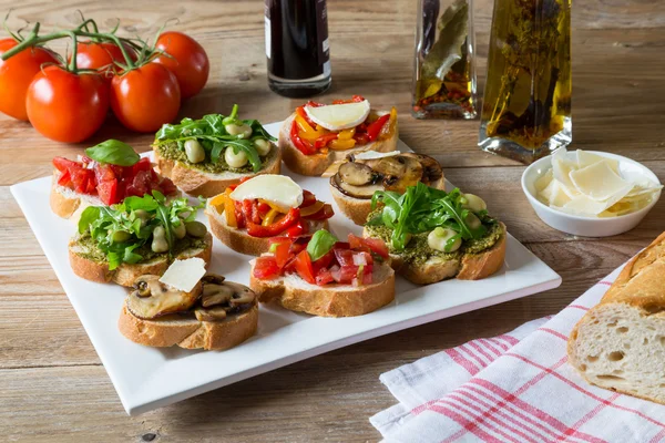 Bruschetta with beans and arugula, mushrooms, goat cheese — Stock Photo, Image