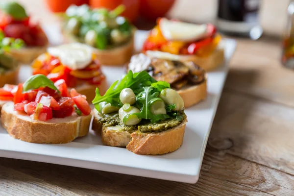 Bruschetta with beans and arugula, mushrooms, goat cheese — Stock Photo, Image