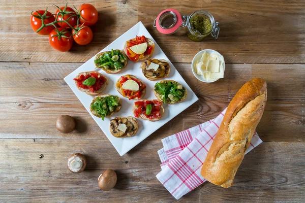 Bruschetta with beans and arugula, mushrooms, goat cheese — Stock Photo, Image