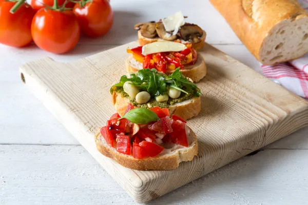 Bruschetta with beans and arugula, mushrooms, goat cheese — Stock Photo, Image