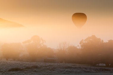 Hot Air Balloon Rises Thru The Mist clipart