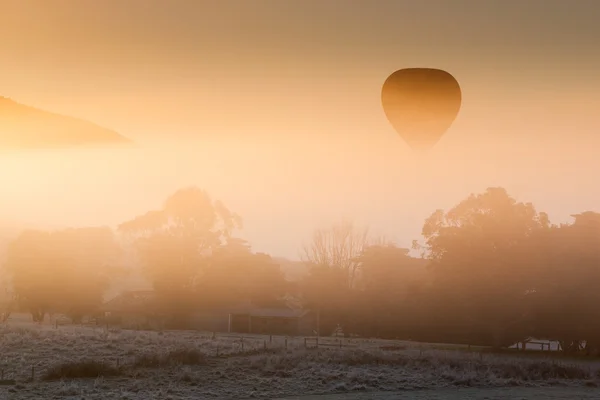 Heißluftballon steigt durch den Nebel — Stockfoto