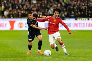 MELBOURNE, AUSTRALIA - 15 Temmuz 2022 tarihinde MCG 'de oynanan sezon öncesi dostluk maçında Manchester United' dan Zidane Iqbal ve Melbourne Victory 'den Chris Ikonomidis top için mücadele etti.