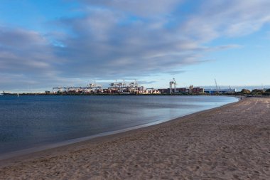 Westport Reserve Beach with a view towards Webb Dock and Princes Pier at sunset on a winters evening in Melbourne, Victoria, Australia
