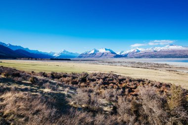 The Highway 80 road towards Mt Cook Village along Lake Pukaki on a clear spring day in Canterbury, New Zealand