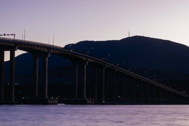Günbatımında ikonik Tasman Köprüsü açık bir bahar akşamı Hobart, Tazmanya, Avustralya 'daki Derwent Nehri' ni geçer. Clarence 'ın kıyılarından çekildi.