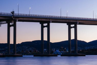 Günbatımında ikonik Tasman Köprüsü açık bir bahar akşamı Hobart, Tazmanya, Avustralya 'daki Derwent Nehri' ni geçer. Clarence 'ın kıyılarından çekildi.