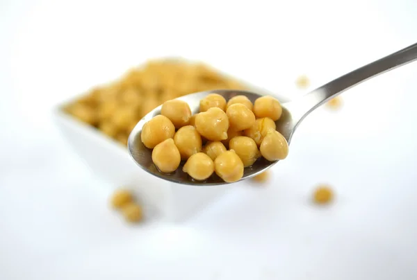 Chickpeas in small white dish with spoon — Stock Photo, Image