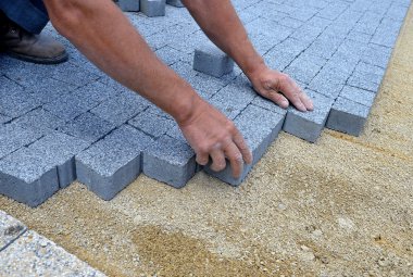 bir işçi bir kaldırım tuğla yaptı.