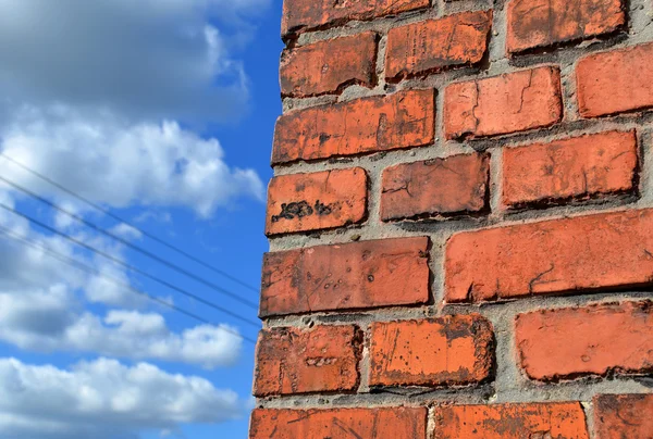 Red brick wall against blue sky background. — Stock Photo, Image