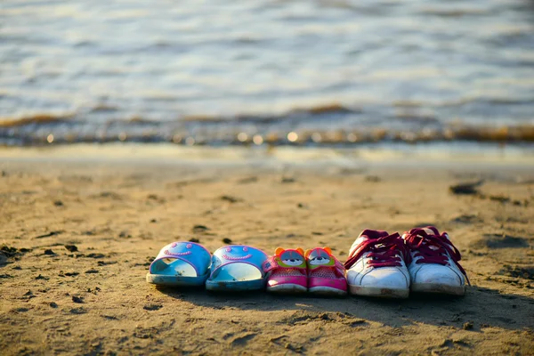 Tre paia di scarpe sulla spiaggia Foto Stock