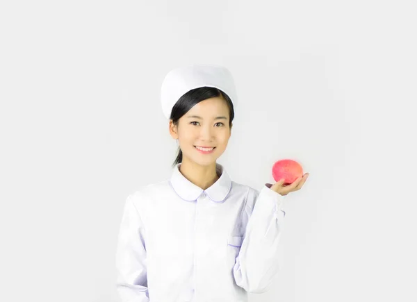Verpleegster met pil en apple op lab Stockfoto