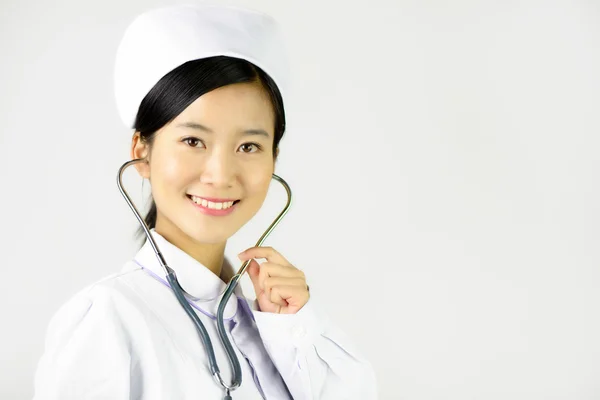 Mooie verpleegster met een stethoscoop op een witte achtergrond geïsoleerde Stockfoto